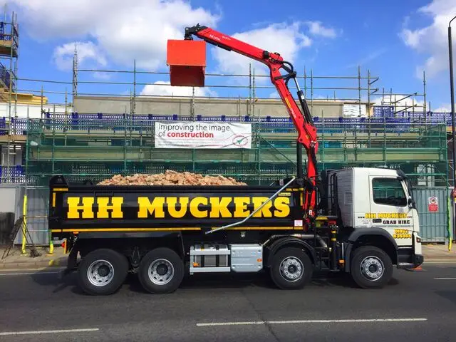 HH Muckers 8-wheel grab lorry loading construction waste on site